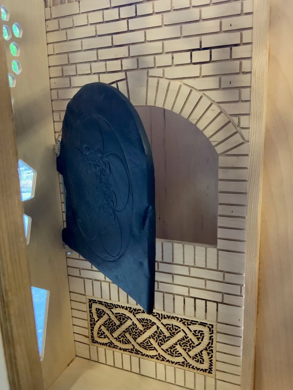 Voronoi hexagonal window panels, irregular pentagon cells cut from white-painted plywood with black acrylic mirror inserts, a gold reflection catching the light in one cell