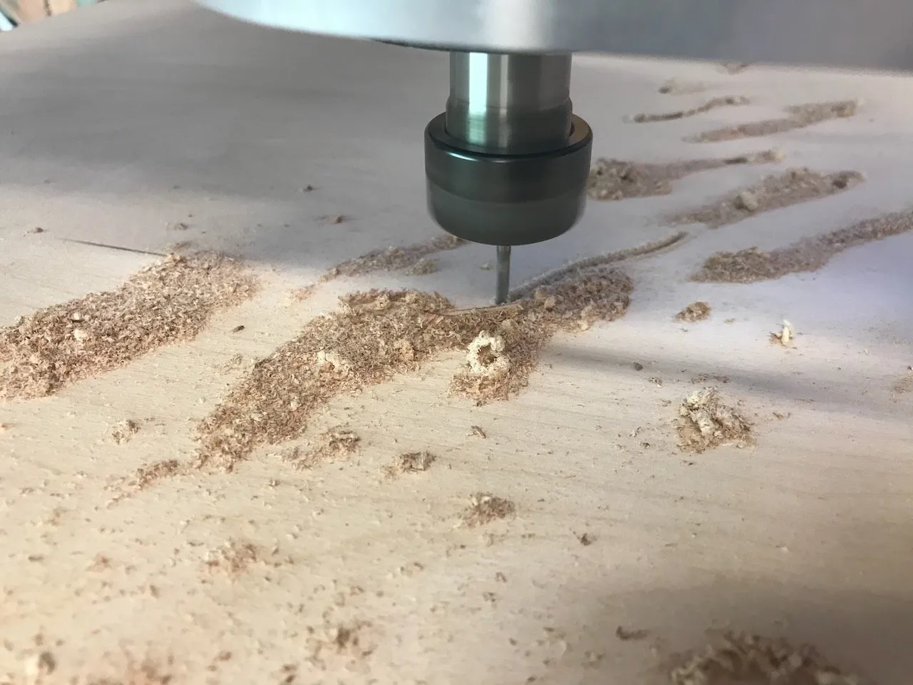 CNC router carving sinusoidal wave-pattern railing panels; multiple panels being cut simultaneously, the wave motif emerging clearly from white plywood