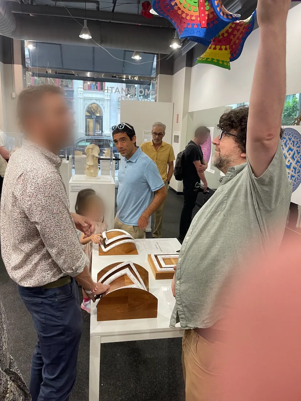Edmund Harriss explaining the Holonomy Blocks to visitors at the opening reception, with a child and other attendees gathered around