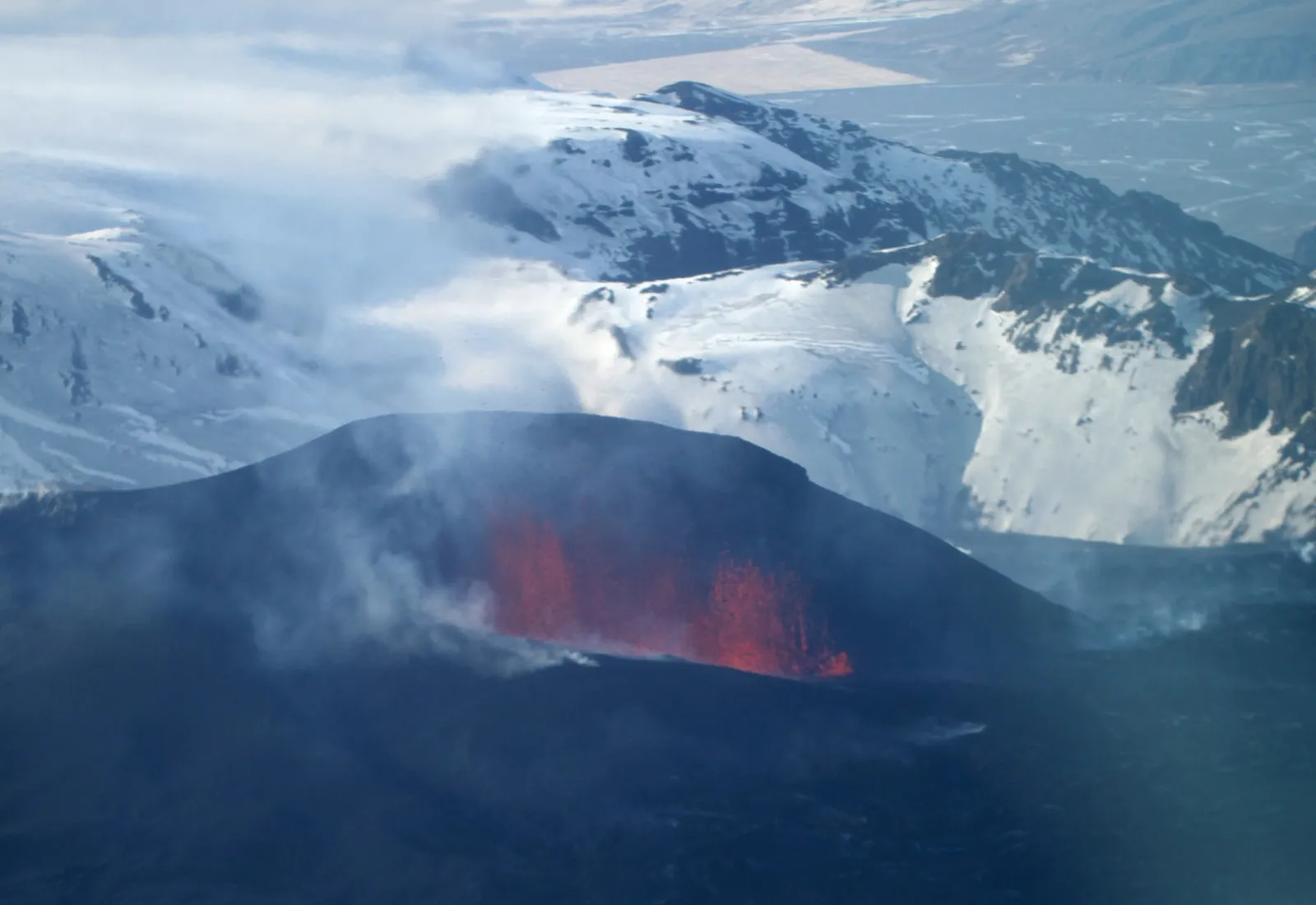 Aerial view of a volcanic eruption in Iceland,  the geological drama that frames the sculpture on Heimaey