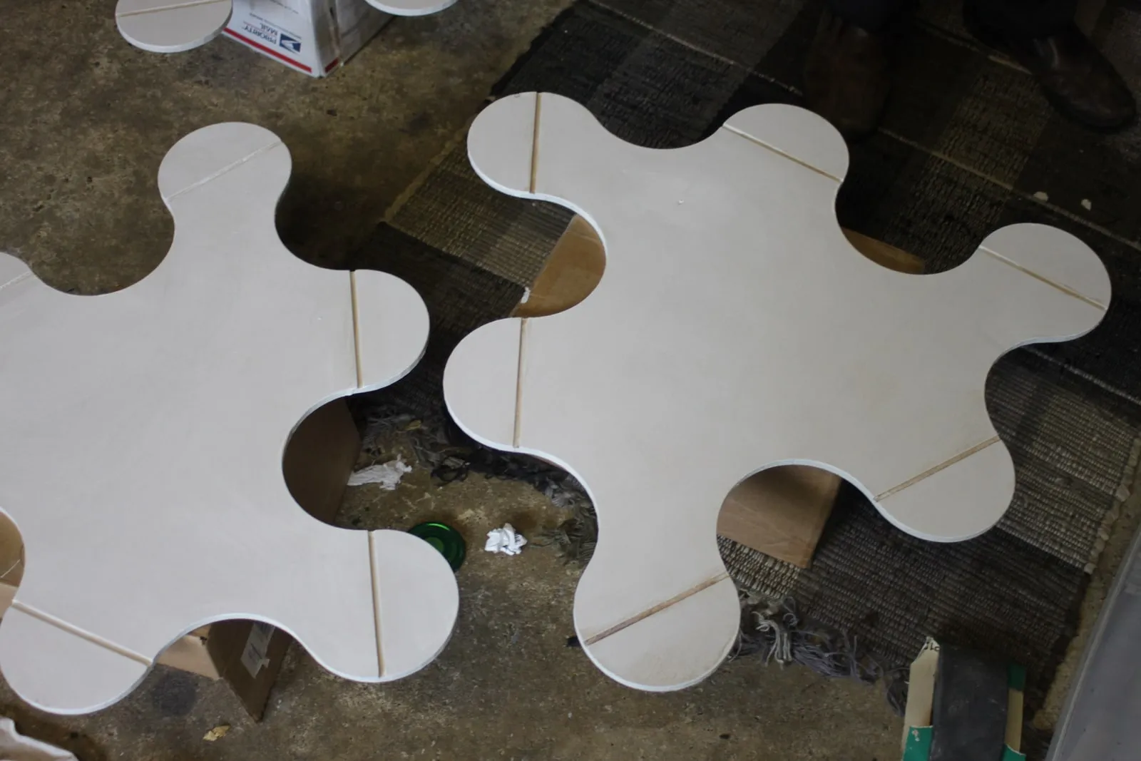 Two finished interlocking pieces on the garage floor,  the curved tab-and-slot hinge geometry