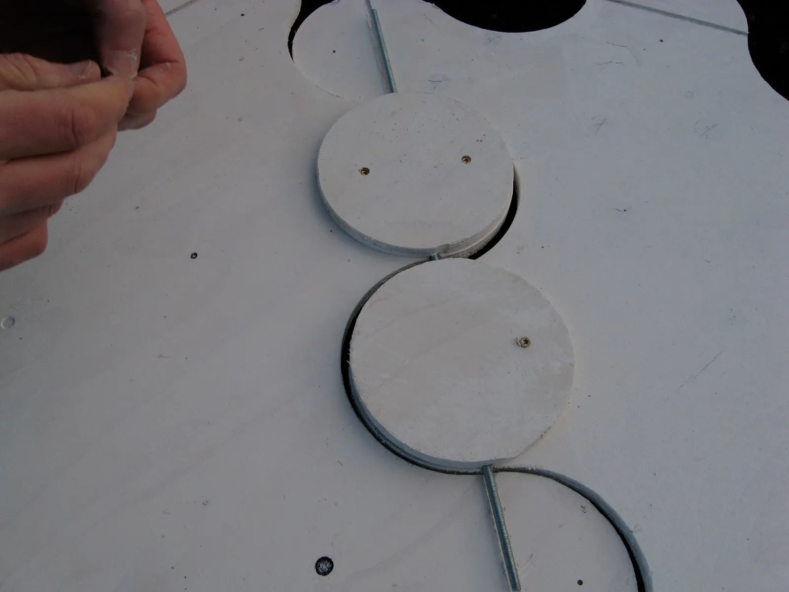 Close-up: a connector disc held in position on the lava, metal rod threaded through both pieces
