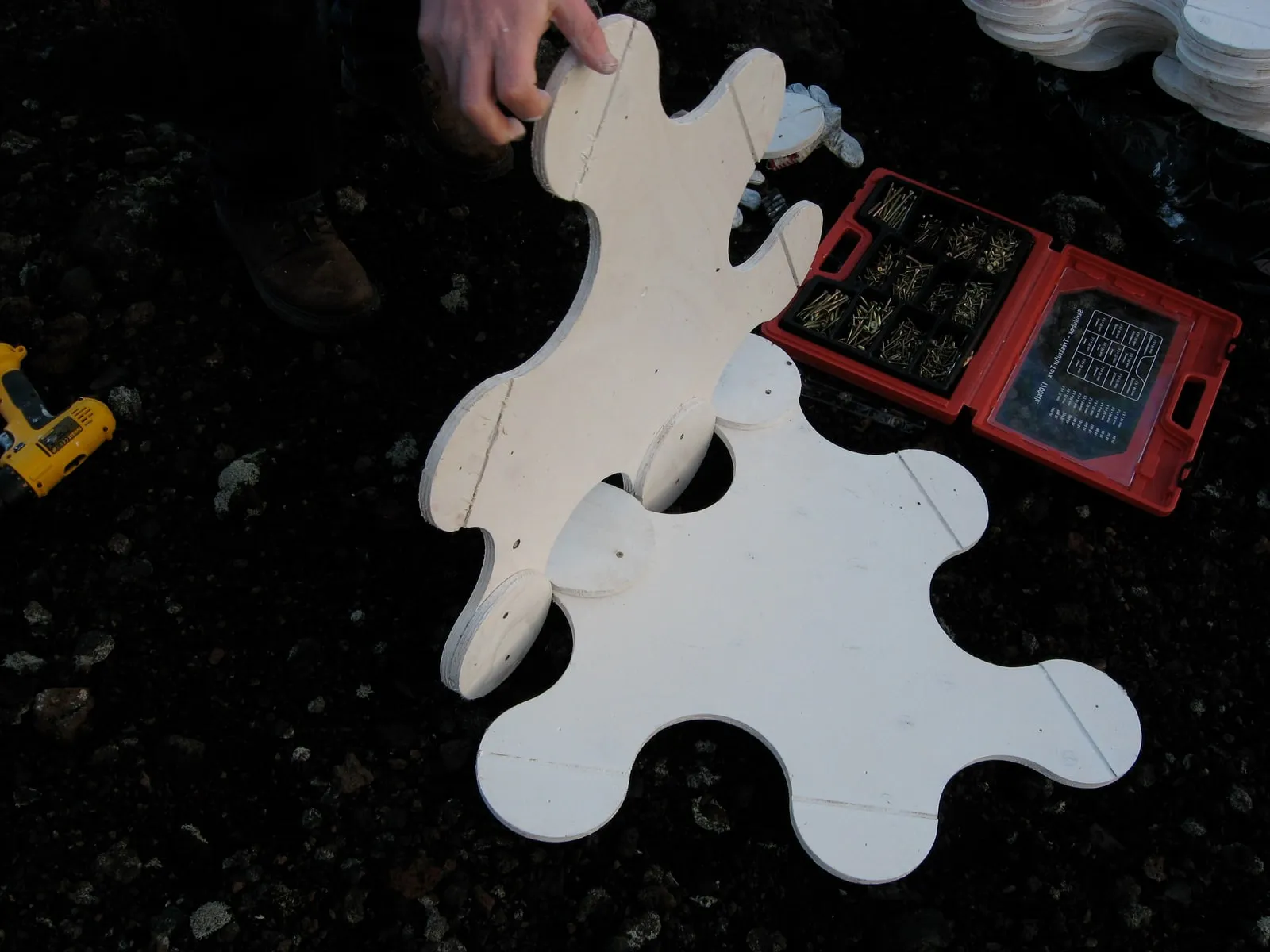 Two pieces being linked on the lava field, showing the tab-and-disc joint that allows each piece to pivot