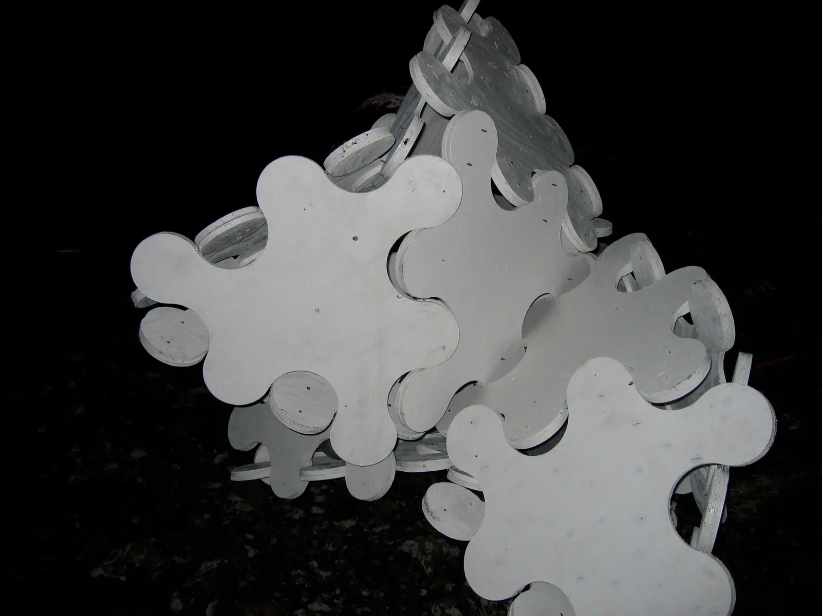 The sculpture at an intermediate stage,  an open deltahedron glowing against the Eldfell lava field at night