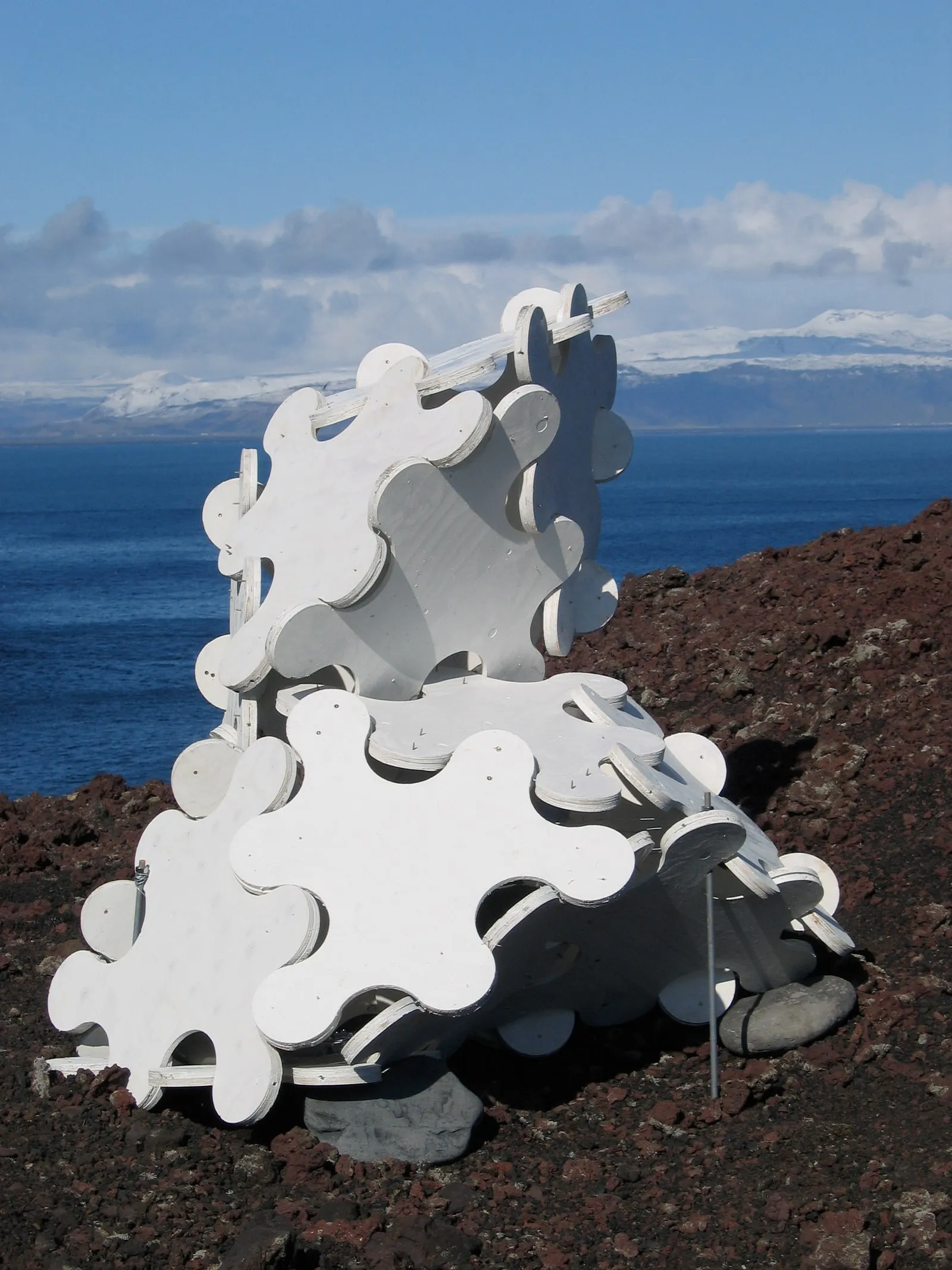 Sculpture System 5 on Heimaey, looking toward the snow-capped Icelandic mainland across the sea